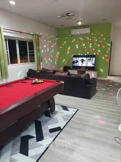 Spacious living room with pool table and entertainment setup, perfect for leisure and relaxation.