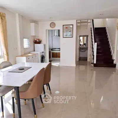 Spacious open-plan living area with modern dining set and staircase