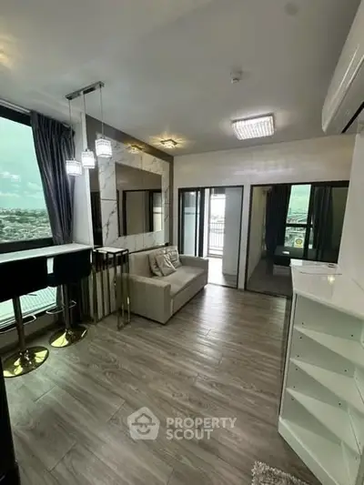 Modern living room with stylish decor and large windows offering a stunning view, perfect for urban living.