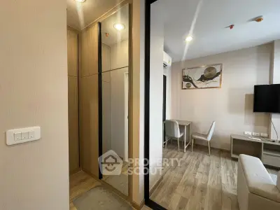 Modern apartment interior with stylish decor and wooden flooring, featuring a cozy living area and mirrored wardrobe.