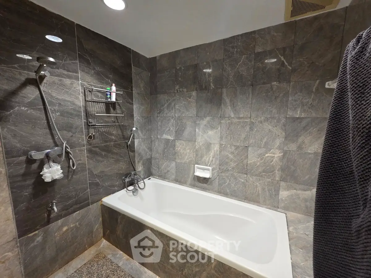 Luxurious bathroom with elegant marble tiles and modern bathtub.