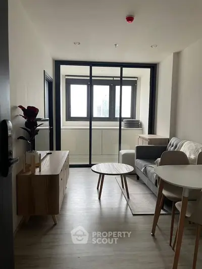 Modern living room with sleek furniture and large window for natural light.