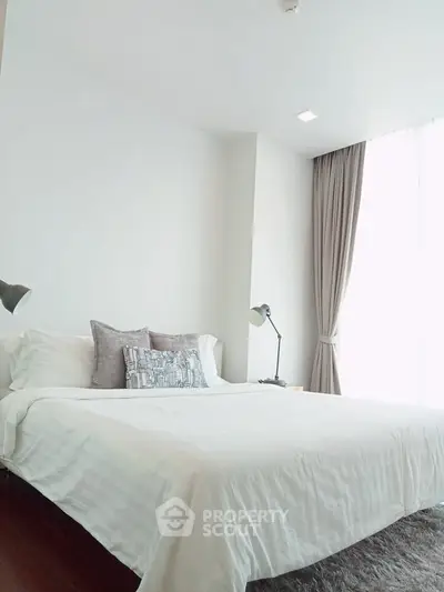 Bright and spacious bedroom with modern decor and large window for natural light.