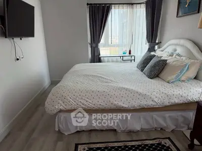 Cozy bedroom with stylish decor and large window for natural light