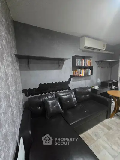 Modern living room with black leather sofa and wall-mounted shelves
