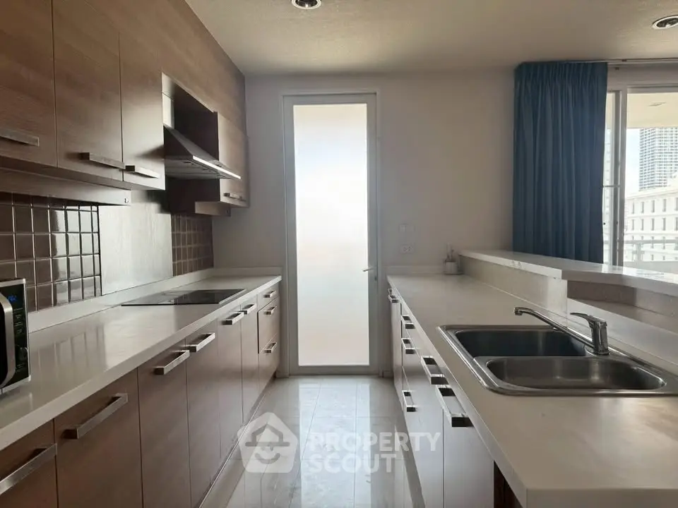 Modern kitchen with sleek cabinetry and ample counter space in a high-rise apartment.