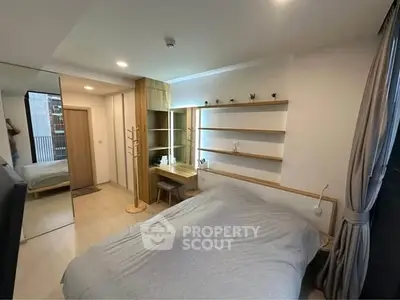 Modern bedroom with cozy bed, built-in shelves, and natural light.