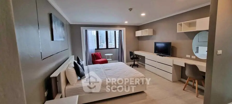 Spacious modern bedroom with stylish decor and city view, ideal for urban living.