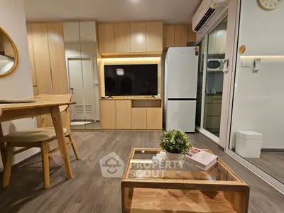 Modern living room with wooden furniture and sleek kitchen appliances in a cozy apartment.