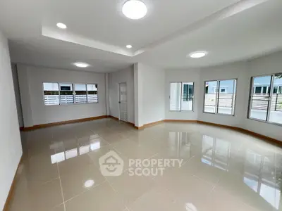 Spacious empty living room with large windows and glossy tiled floor
