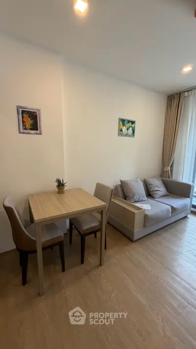 Modern living room with cozy sofa and dining area, featuring elegant decor and natural light.