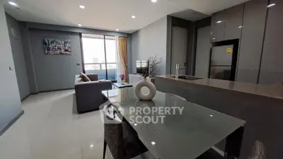Modern open-plan living room with sleek kitchen and stylish decor in a high-rise apartment.