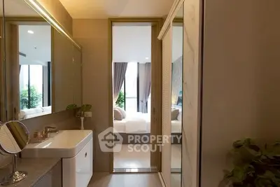Modern bathroom with sleek design leading to a cozy bedroom with natural light.
