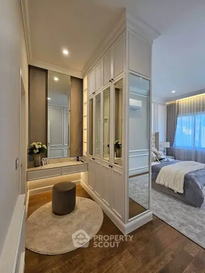 Luxurious bedroom with elegant decor and spacious walk-in closet, featuring hardwood floors and ambient lighting.