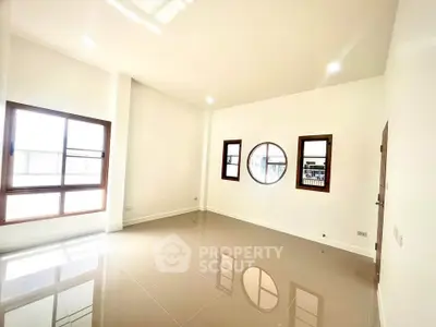 Spacious and bright empty room with large windows and glossy tiled floor
