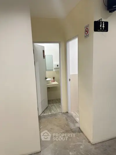 Simple public restroom entrance with beige walls and signage