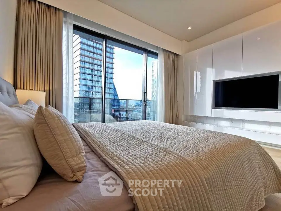 Luxurious bedroom with modern decor and stunning city view from large windows.