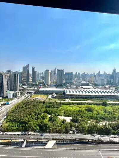 Stunning cityscape view from high-rise building with lush greenery and modern skyline.