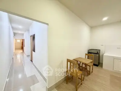 Spacious apartment hallway with dining area and modern kitchen appliances.