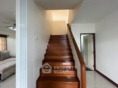 Elegant wooden staircase in modern home with cozy living room view