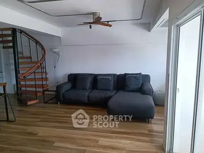 Modern living room with spiral staircase and stylish sofa