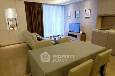 Modern living room with open kitchen, cozy sofa, and elegant dining area in a stylish apartment.