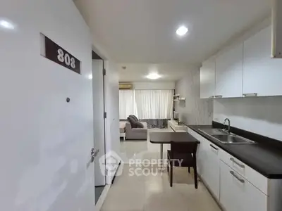 Modern apartment interior with open kitchen and cozy living area, room number 808 visible.