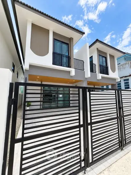 Modern two-story house with sleek design and gated entrance, perfect for contemporary living.