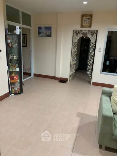 Spacious living room with tiled floor and decorative archway in modern home.