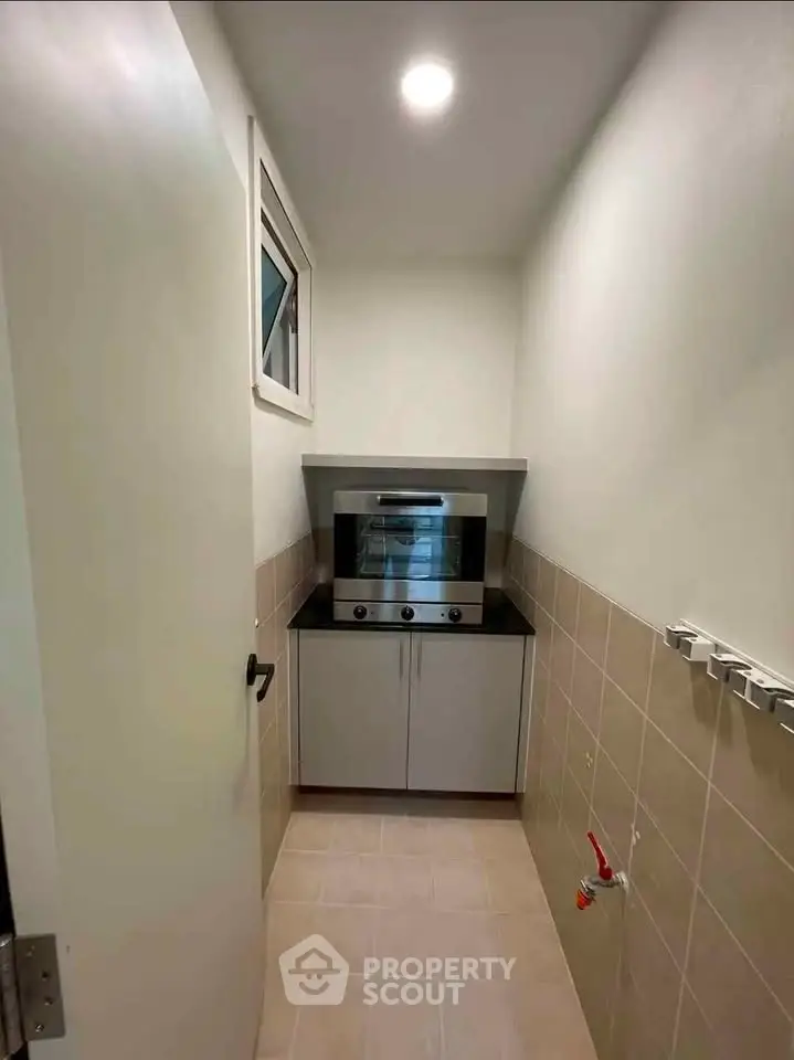 Compact kitchen with modern oven and sleek cabinetry in a cozy real estate unit.