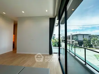 Spacious modern living room with large windows and balcony view