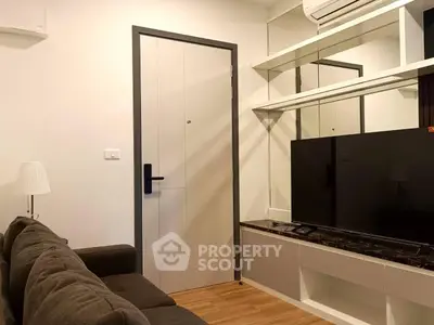 Modern living room with sleek design, featuring a comfortable sofa, wall-mounted TV, and stylish decor.