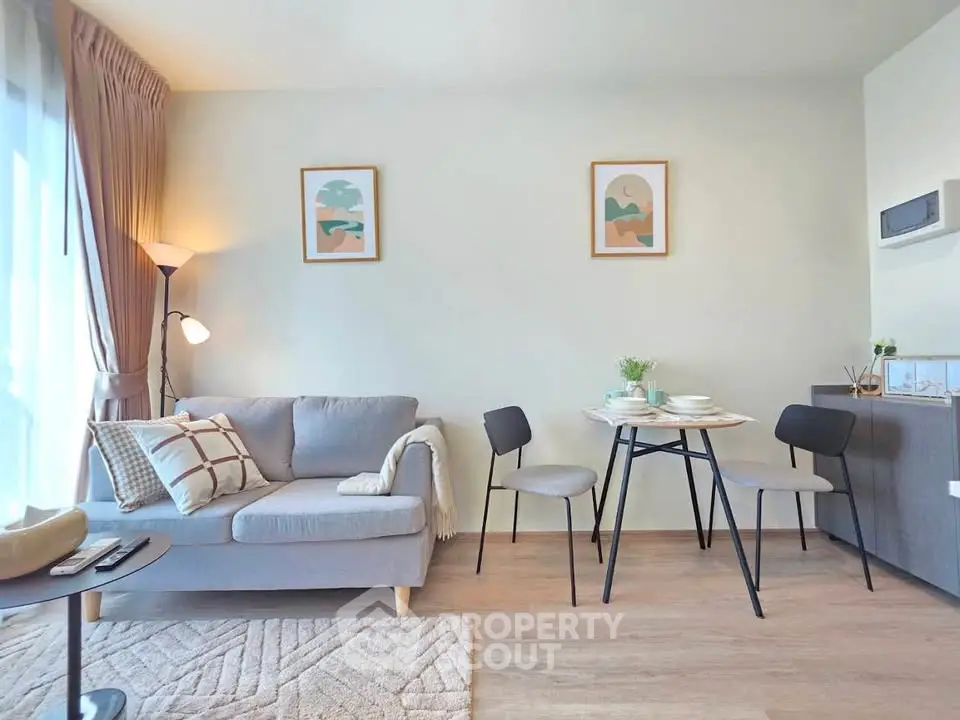 Modern living room with cozy sofa and dining area, bright natural light, stylish decor.