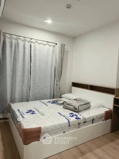 Cozy bedroom with modern decor and natural light, perfect for relaxation and comfort.