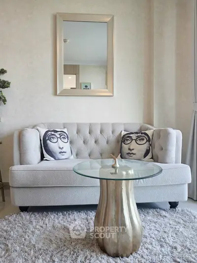 Stylish living room with elegant sofa, artistic cushions, and chic glass coffee table.