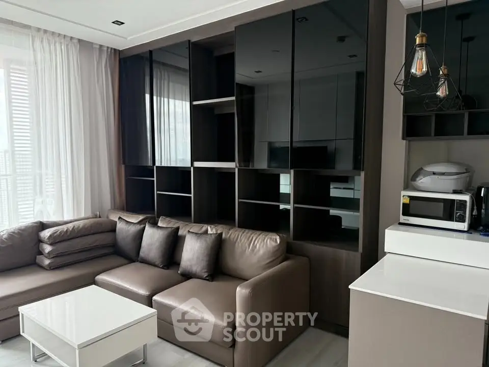 Modern living room with sleek furniture and built-in shelving, featuring a cozy sectional sofa and contemporary lighting.