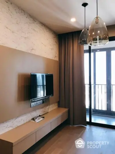 Modern living room with TV, elegant lighting, and balcony access.