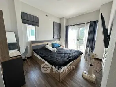 Spacious bedroom with modern decor and balcony access in a stylish apartment.