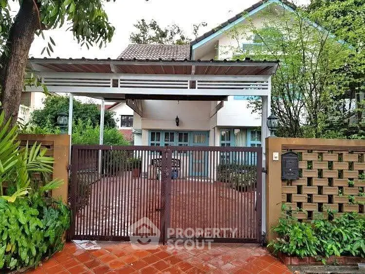 Charming suburban house with gated entrance and lush greenery