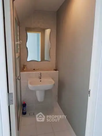Compact bathroom with modern sink and unique mirror design