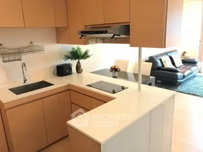 Modern kitchen with sleek cabinetry and open layout adjacent to cozy living room.