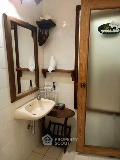 Charming rustic bathroom with wooden accents and frosted glass door