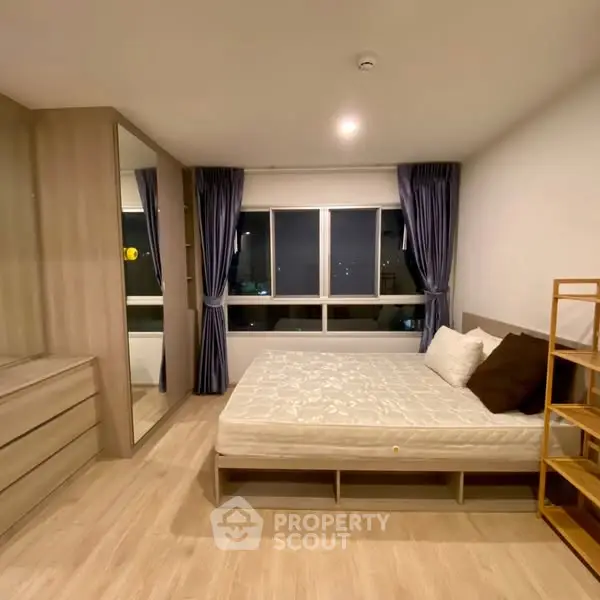 Spacious modern bedroom with large window and stylish decor