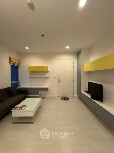 Modern living room with sleek furniture and minimalist design, featuring a cozy sofa and wall-mounted TV.