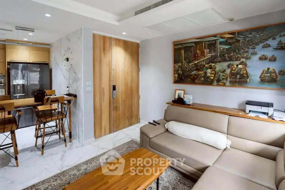 Modern living room with open kitchen, featuring stylish decor and comfortable seating.