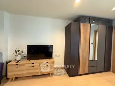 Modern bedroom with sleek wardrobe and TV unit, perfect for stylish living.