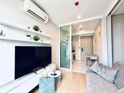 Modern living room with sleek design, featuring a large TV, cozy sofa, and stylish decor in a bright apartment.