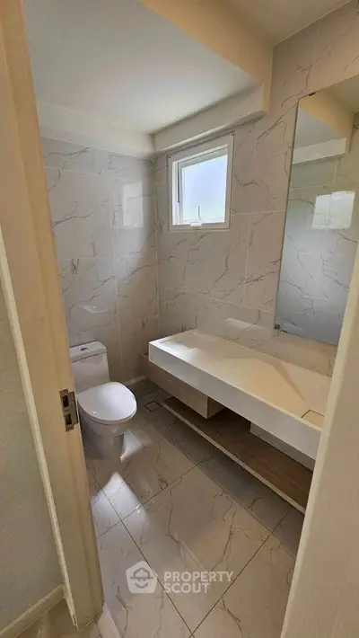 Modern bathroom with sleek design and natural light, featuring elegant marble tiles and contemporary fixtures.
