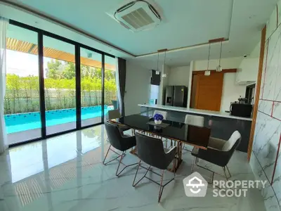 Luxurious dining area with pool view and modern kitchen in open layout