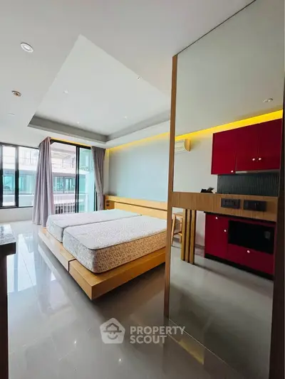 Modern bedroom with sleek design and vibrant red cabinetry, featuring large windows for natural light.